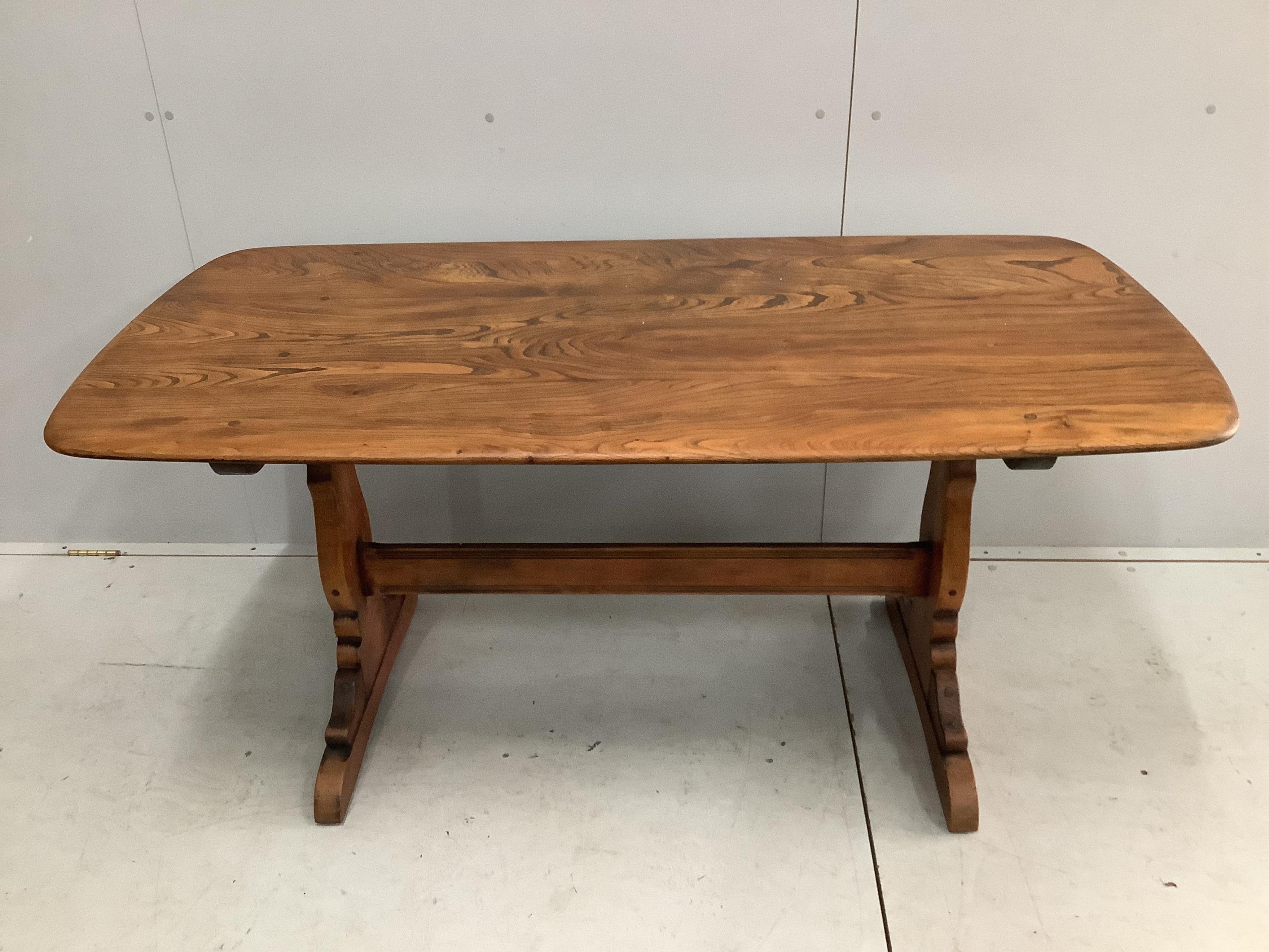 An Ercol elm topped dining table, width 150cm, depth 76cm, height 72cm and a set of four stained beech and elm dining chairs, height 97cm. Condition - some rubbing to the frames of the chairs, otherwise fair to good